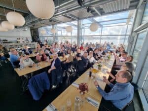 Elegant corporate event with professionals dining in a modern, glass-walled venue.