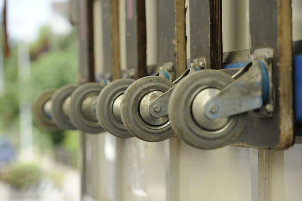 Sliding door casters with wheels and mounting hardware for smooth operation.